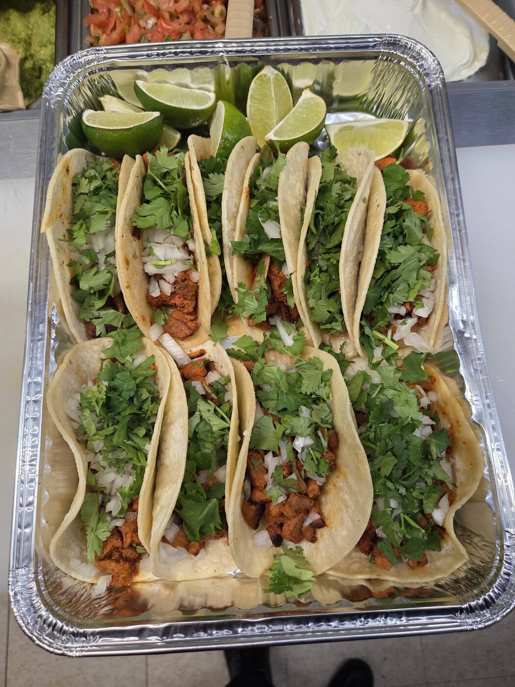 Street tacos topped with cilantro, onion and fresh avocado