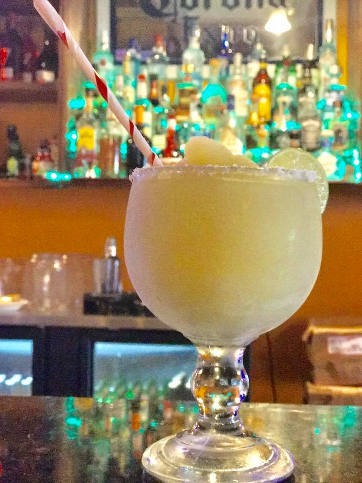 Frozen margarita with a salted rim and lime at the bar