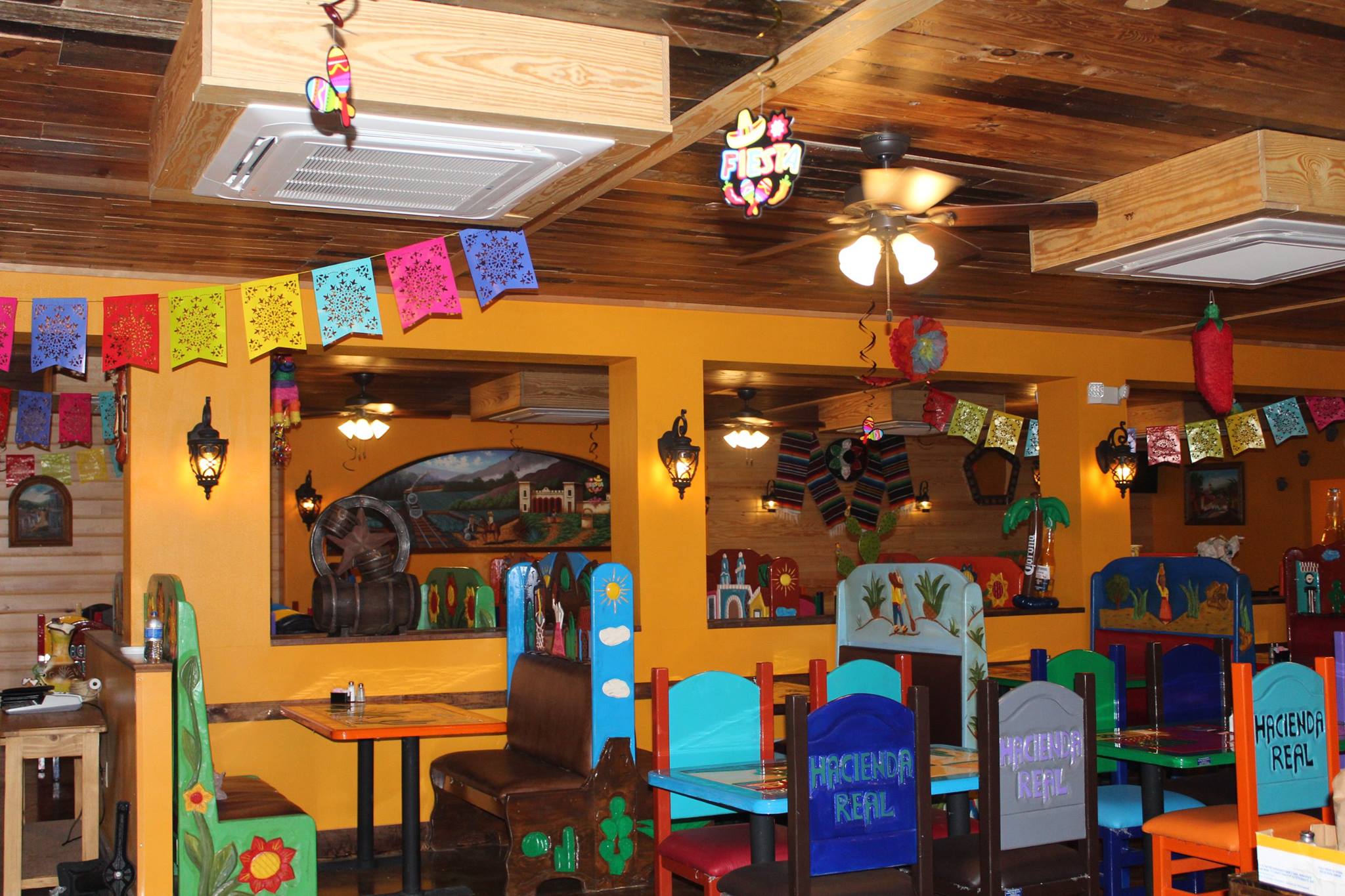 Interior of Hacienda Real with painted booths, lanterns and papel picado