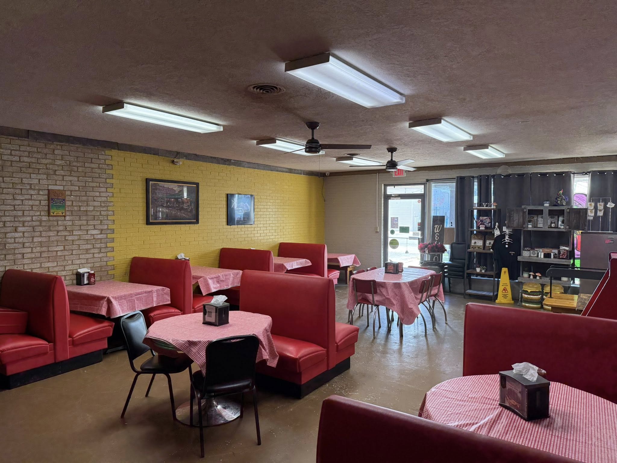 The cheerful dining room at Love Bonez with red booths and gingham tablecloths