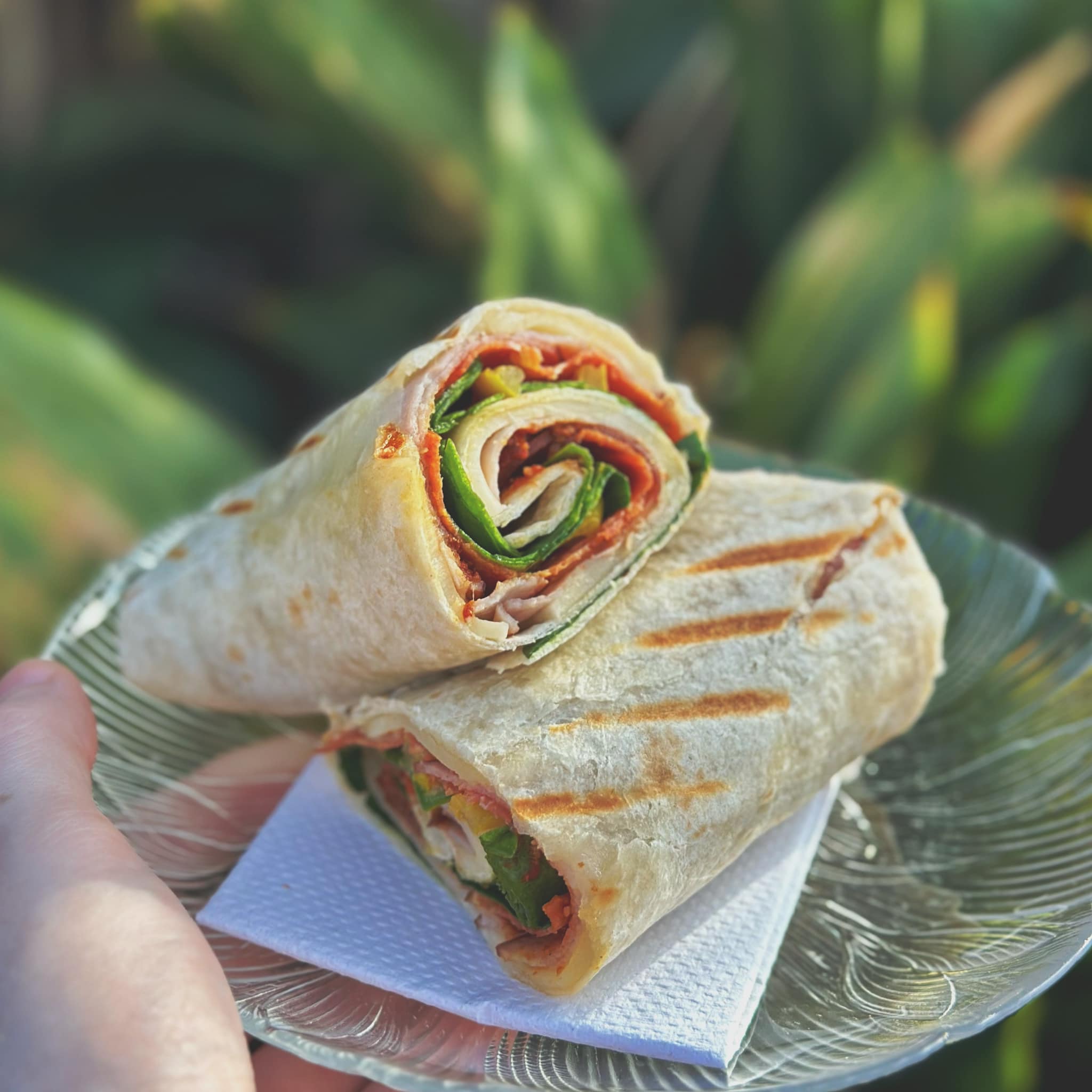 A freshly pressed grilled wrap, sliced and stacked on a glass plate.